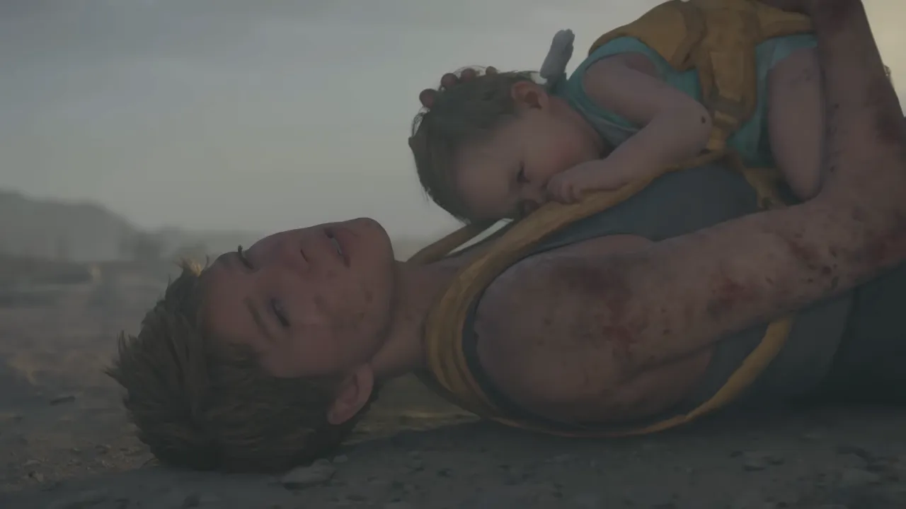 Injured Fragile on the ground carrying Lou in Death Stranding 2: On the Beach